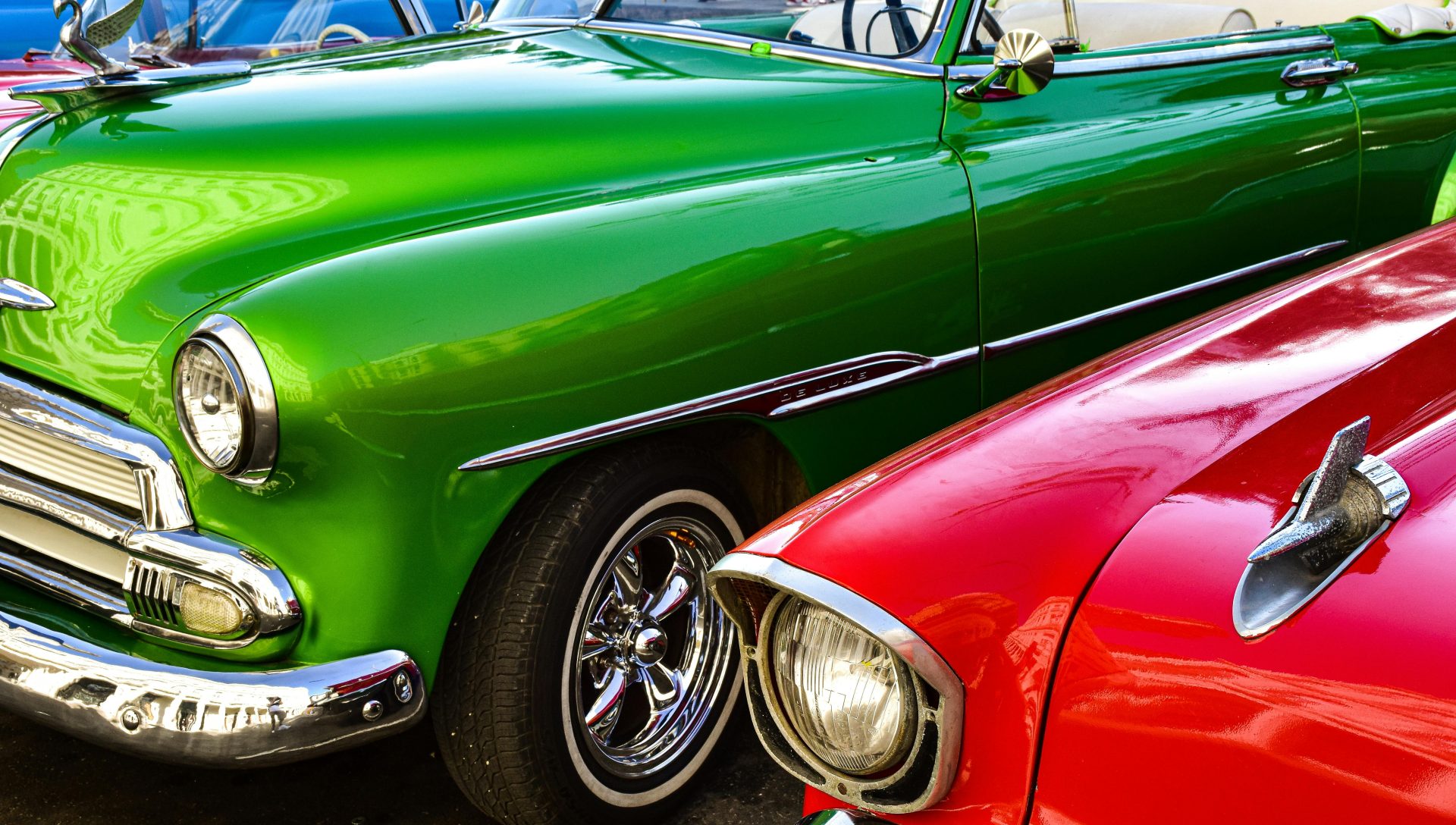 Nahaufnahme klassischer, grüner und roter Chevrolet-Oldtimer, die nebeneinander geparkt sind und ihren Retro-Stil zur Schau stellen.